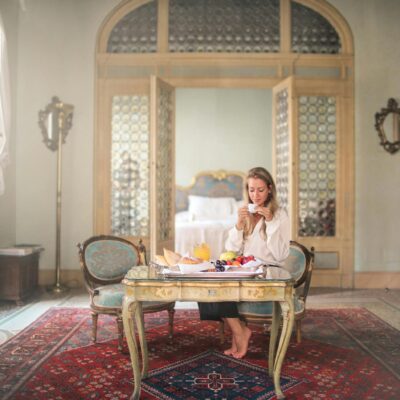 Woman enjoying breakfast in luxury hotel room